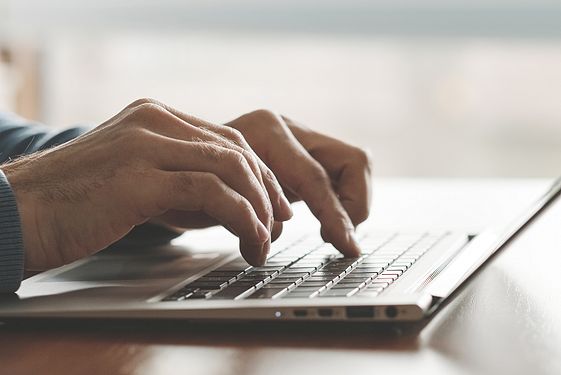 Person typing on laptop keyboard