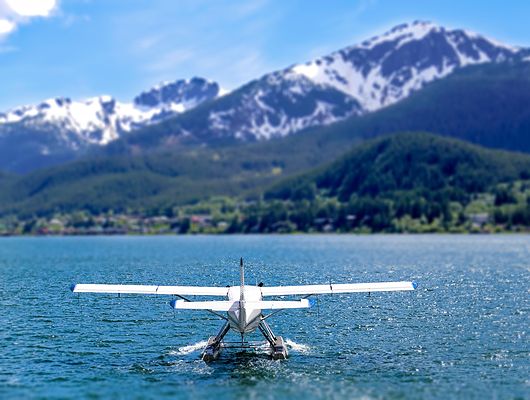 Small plane on the water with mountains in the background