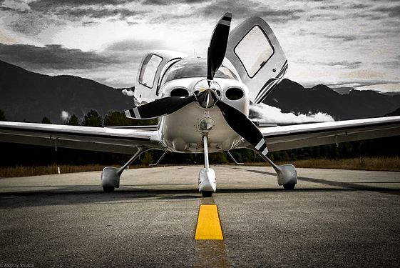 Small airplane on road with mountains 