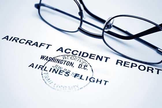 Aircraft accident report with glasses on paperword