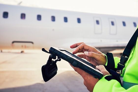 Worker on tablet next to airplane